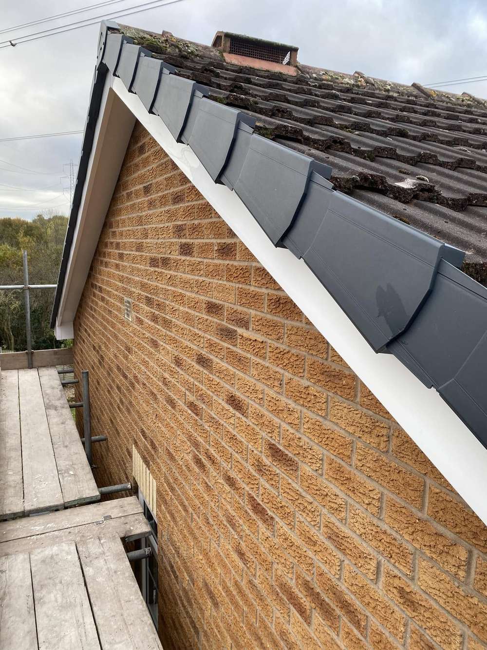 Anthracite dry verge along a brick gable with white fascia