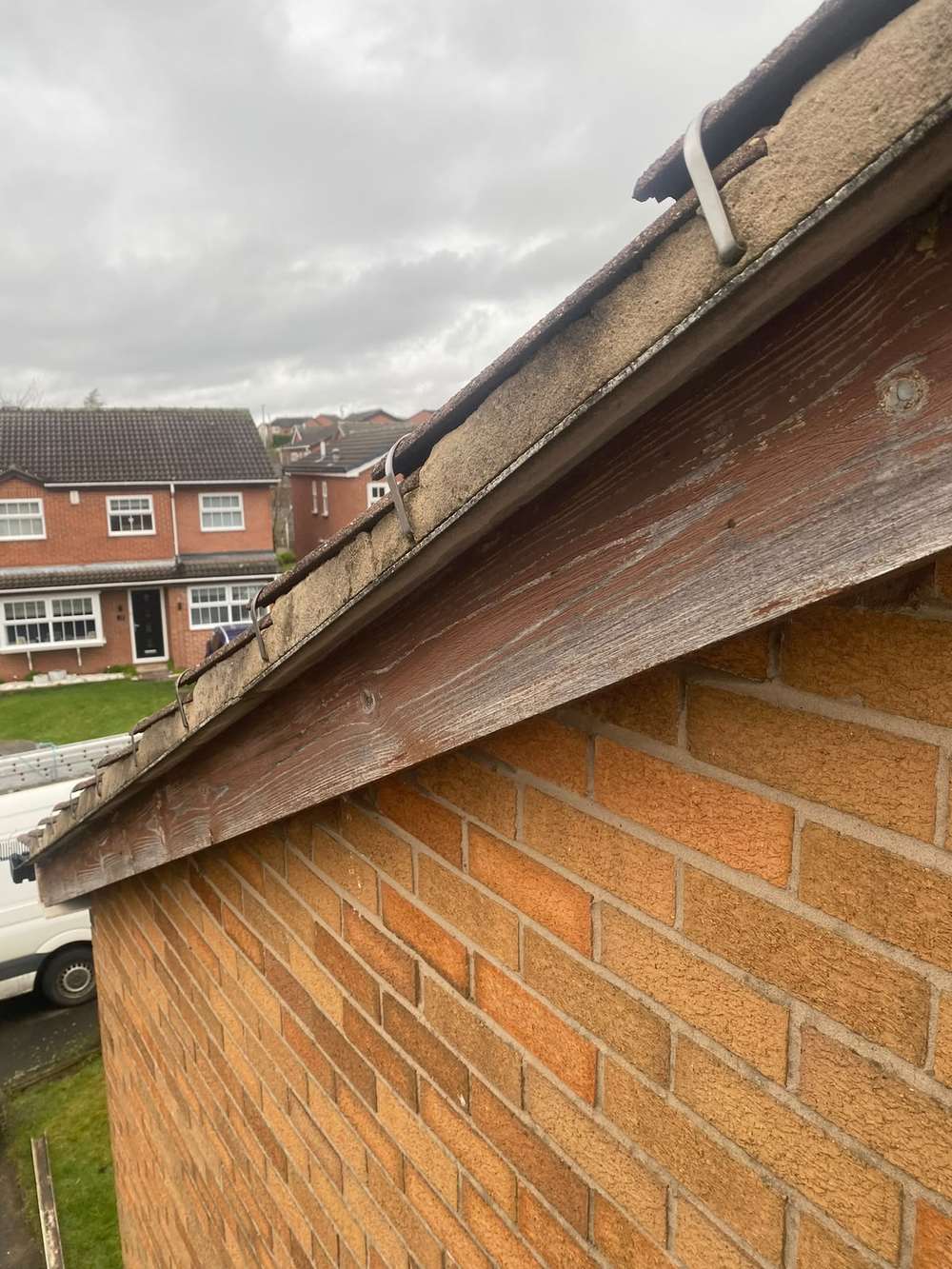 Weathered grey timber board along a gable edge, before